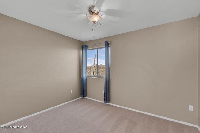 spare room with light carpet, visible vents, baseboards, and a ceiling fan