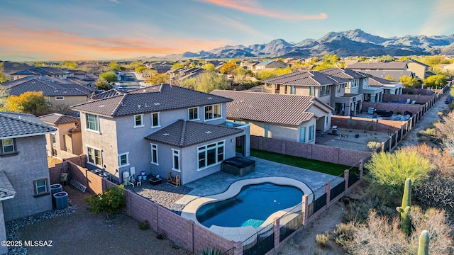 exterior space with central air condition unit, a residential view, a mountain view, and a fenced backyard