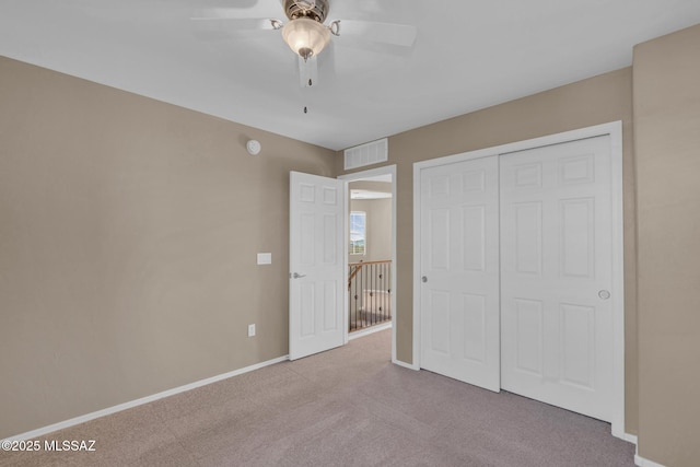 unfurnished bedroom featuring carpet, visible vents, baseboards, ceiling fan, and a closet