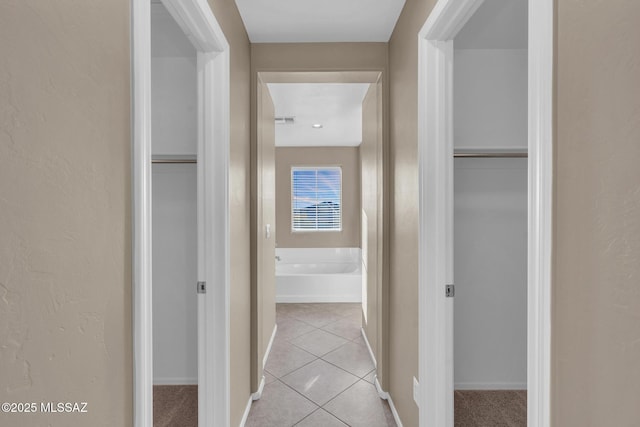 hall with baseboards and light tile patterned flooring