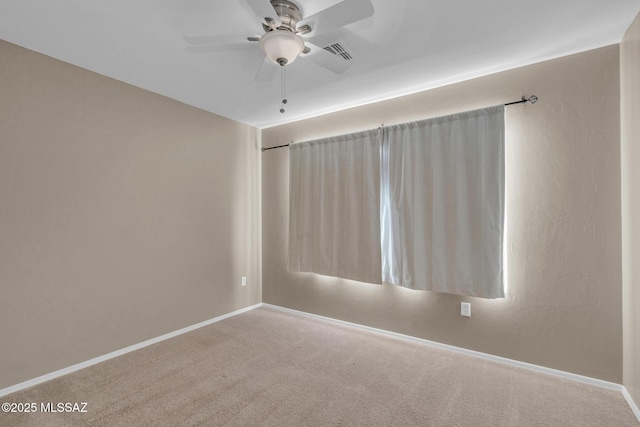 unfurnished room featuring baseboards, visible vents, a ceiling fan, and carpet