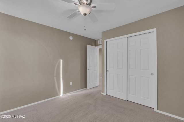 unfurnished bedroom with a closet, carpet flooring, visible vents, and baseboards