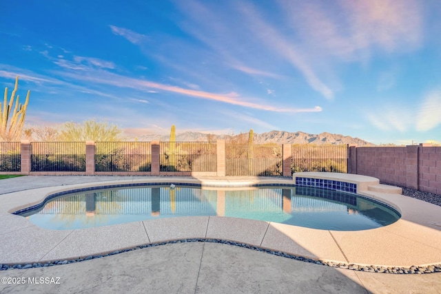 view of swimming pool featuring a fenced in pool, a mountain view, and a fenced backyard