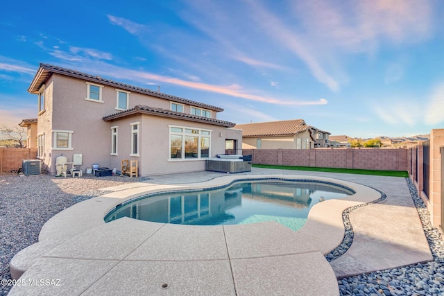 view of pool featuring cooling unit, a fenced in pool, a fenced backyard, a hot tub, and a patio area