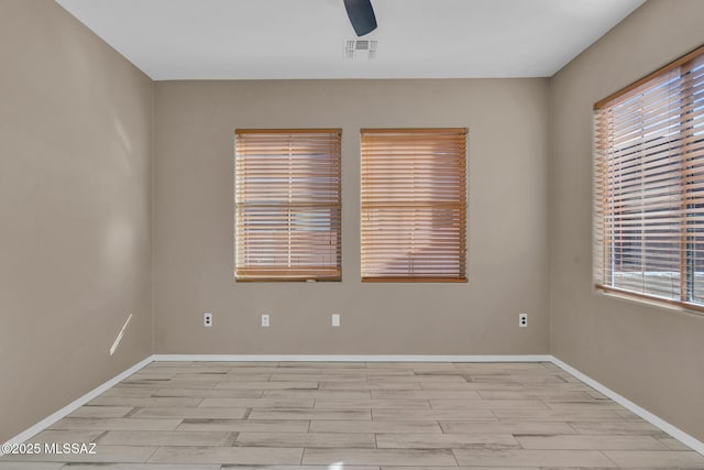 spare room with visible vents, wood finish floors, baseboards, and ceiling fan