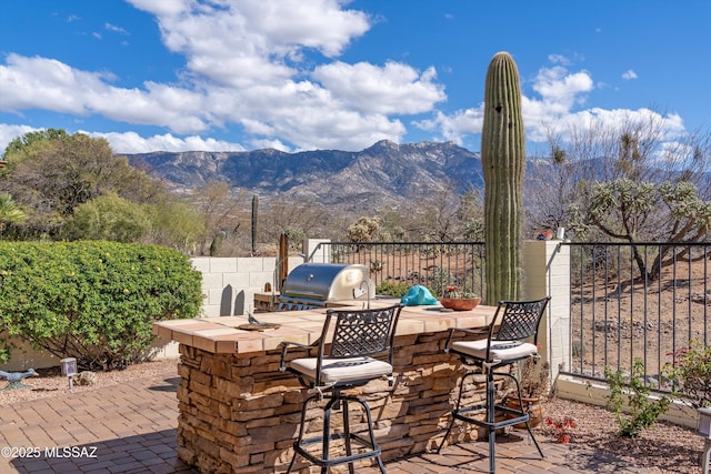 64671 E Canyon Shadows Ln, Tucson, AZ 85739 - view of patio / terrace featuring outdoor dry bar, grilling area, fence, area for grilling, and a mountain view