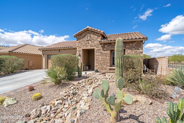 7006 W Cape Final Trl, Marana, AZ 85658 - mediterranean / spanish house featuring stone siding, a tile roof, a garage, and concrete driveway