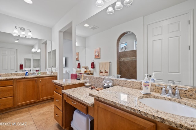 bathroom with a sink, visible vents, two vanities, and tile patterned floors