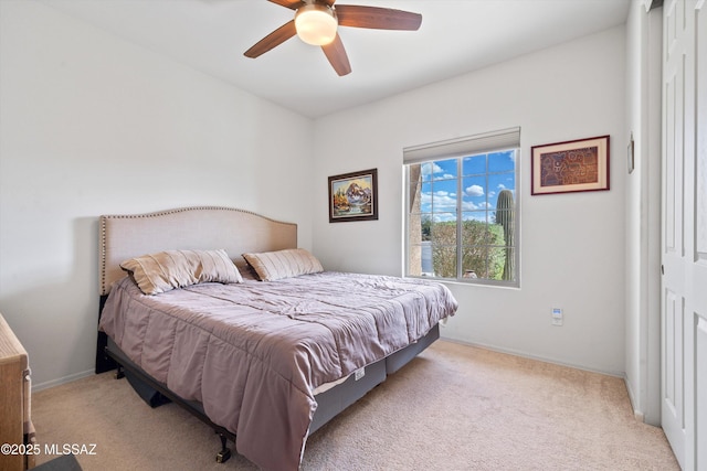 carpeted bedroom with a closet, baseboards, and a ceiling fan