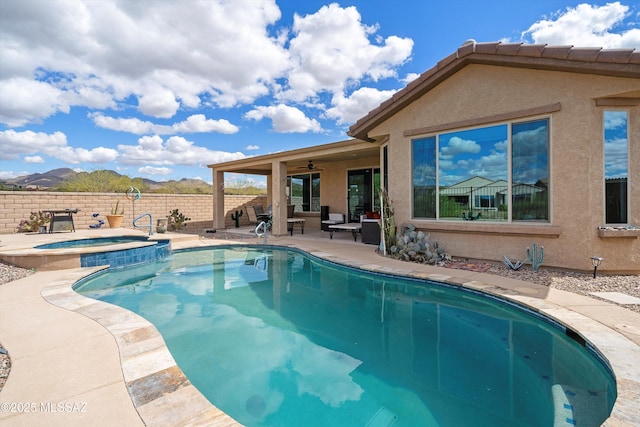 view of pool featuring fence, a pool with connected hot tub, ceiling fan, and a patio area