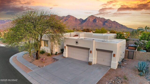 499 W Windowmaker Rd, Tucson, AZ 85737 - pueblo-style house featuring a mountain view, driveway, a garage, and stucco siding