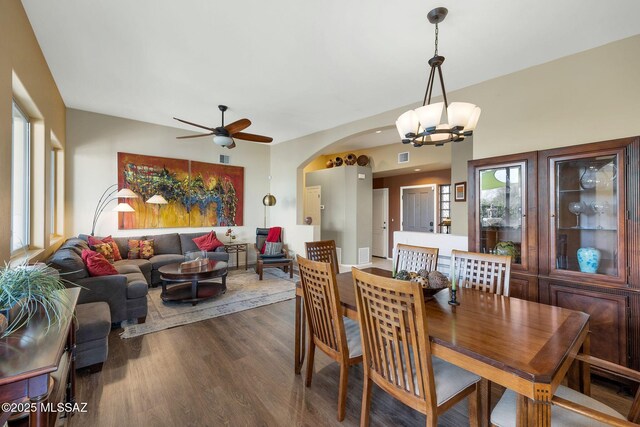 499 W Windowmaker Rd, Tucson, AZ 85737 - dining area with ceiling fan with notable chandelier, arched walkways, and dark wood finished floors