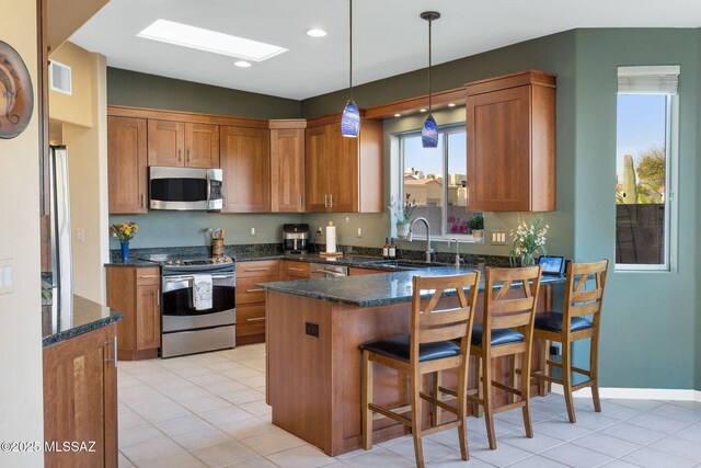 499 W Windowmaker Rd, Tucson, AZ 85737 - kitchen featuring a peninsula, visible vents, brown cabinets, appliances with stainless steel finishes, and a sink