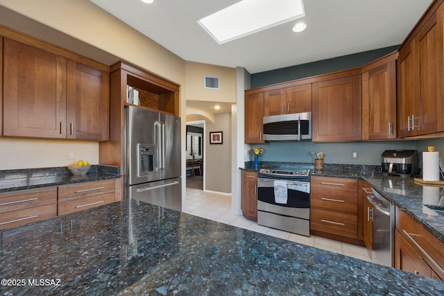 499 W Windowmaker Rd, Tucson, AZ 85737 - kitchen featuring visible vents, light tile patterned floors, arched walkways, appliances with stainless steel finishes, and brown cabinetry