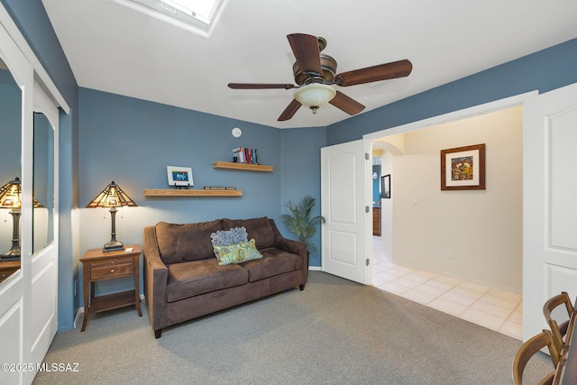 499 W Windowmaker Rd, Tucson, AZ 85737 - tiled living area with arched walkways, carpet flooring, a ceiling fan, and a skylight