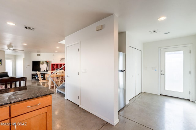 kitchen with visible vents, recessed lighting, concrete flooring, and freestanding refrigerator