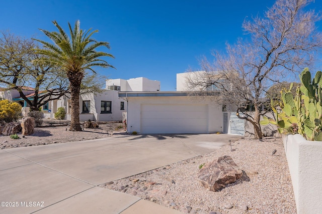 southwest-style home featuring stucco siding, driveway, and an attached garage