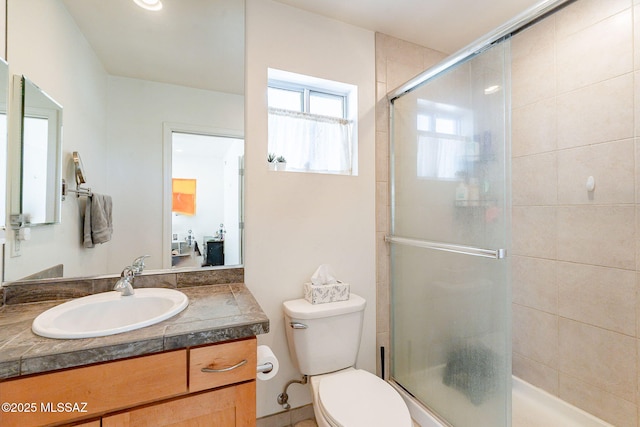 full bath with a tile shower, toilet, and vanity