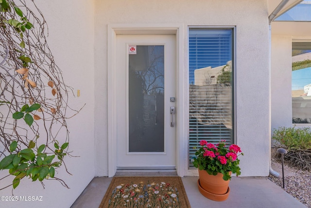 entrance to property featuring stucco siding