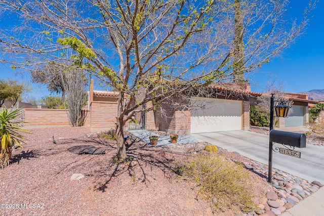 view of front of house with a garage, fence, concrete driveway, and a tiled roof