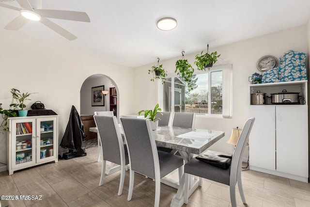 dining room featuring arched walkways and a ceiling fan