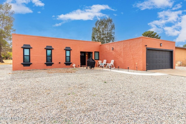 view of front of house with concrete driveway, an attached garage, and stucco siding