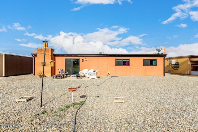 rear view of property featuring stucco siding and a patio area