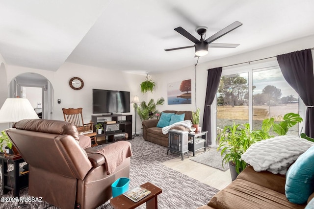 living area featuring arched walkways and a ceiling fan