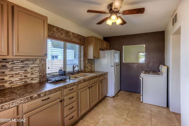 kitchen with a sink, visible vents, white appliances, and dark countertops