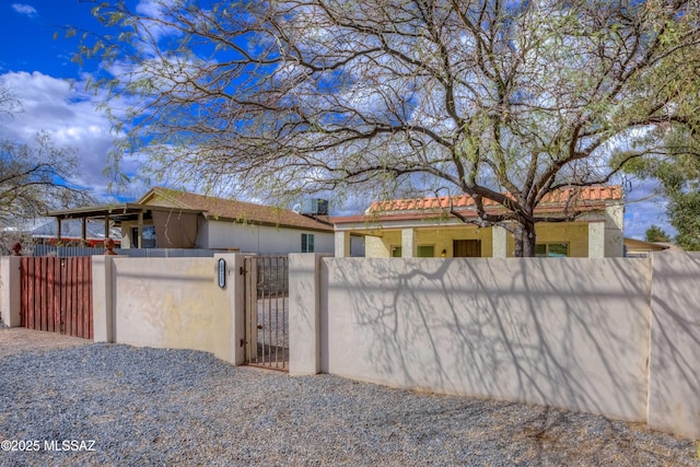 exterior space with a fenced front yard and a gate