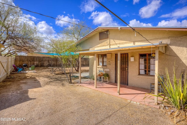 exterior space featuring stucco siding, a patio, and fence