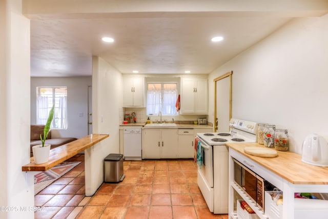 kitchen featuring backsplash, recessed lighting, white cabinets, white appliances, and a sink