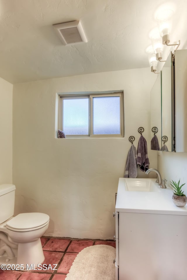 bathroom featuring visible vents, toilet, an inviting chandelier, tile patterned flooring, and vanity