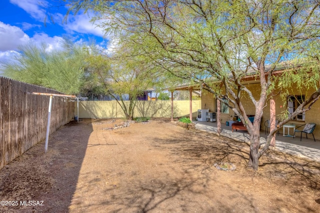 view of yard featuring a fenced backyard, central air condition unit, and a patio