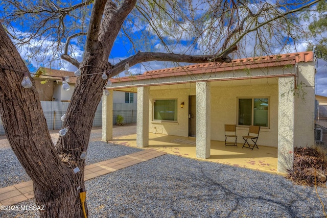 back of house with stucco siding, a patio area, and fence