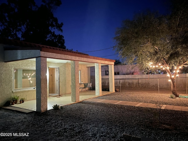 yard at twilight featuring fence and a patio area