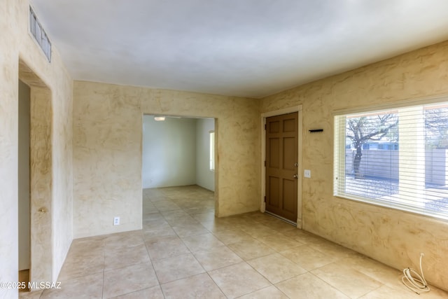 empty room featuring light tile patterned floors and visible vents