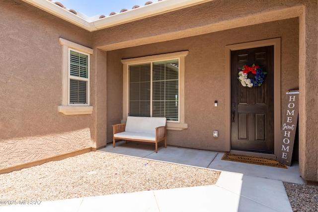 entrance to property featuring stucco siding