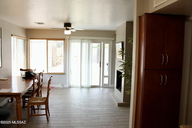 dining space featuring ceiling fan, wood finished floors, visible vents, and baseboards