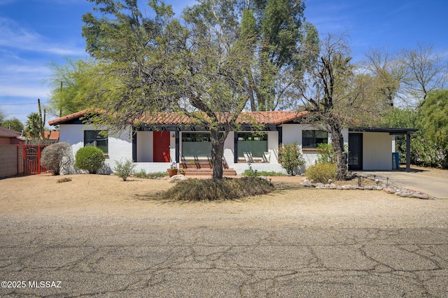 view of front of house with a tile roof, a carport, and concrete driveway