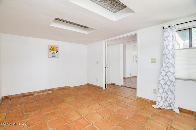 spare room featuring baseboards and light tile patterned flooring