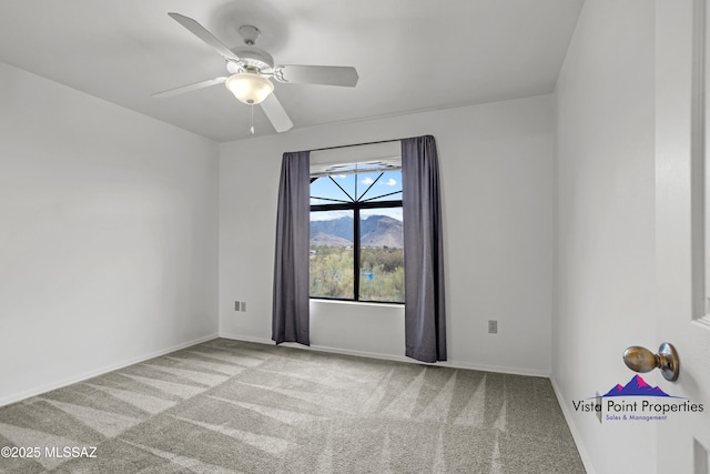 spare room featuring a ceiling fan, baseboards, and carpet floors