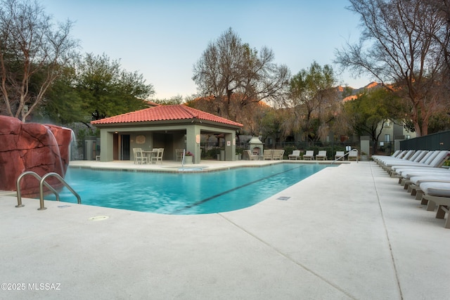 community pool featuring a gazebo, fence, and a patio area