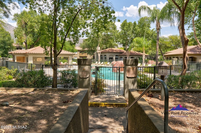 view of play area with a community pool and fence