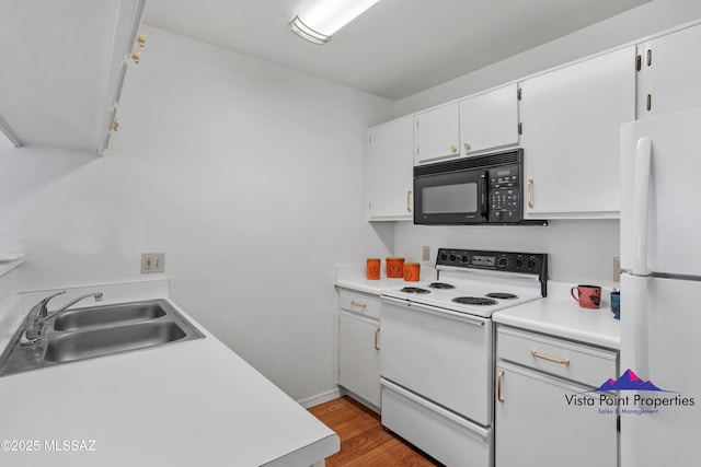 kitchen featuring light wood-style flooring, a sink, white appliances, white cabinets, and light countertops