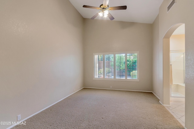 11092 N Eagle Crest Dr, Tucson, AZ 85737 - unfurnished room featuring arched walkways, light carpet, ceiling fan, baseboards, and high vaulted ceiling