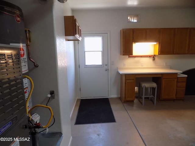 11092 N Eagle Crest Dr, Tucson, AZ 85737 - kitchen featuring brown cabinets, light countertops, concrete floors, and baseboards