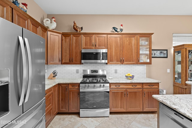 kitchen featuring tasteful backsplash, brown cabinets, and stainless steel appliances