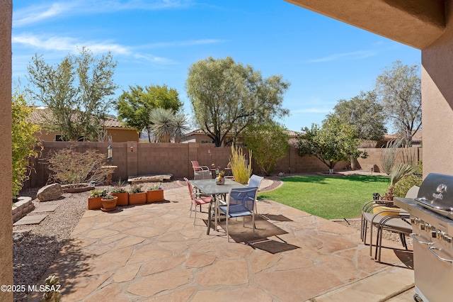 view of patio featuring grilling area, outdoor dining area, and a fenced backyard