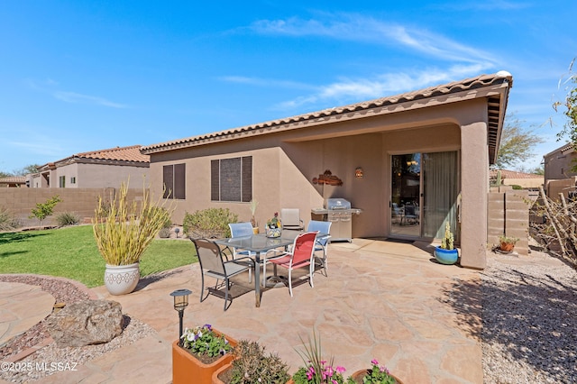 view of patio featuring area for grilling, outdoor dining space, and fence